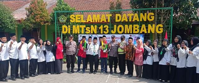 Kepala Sekolah MTsN 13 Sembung, Kecamatan Perak, Kabupaten Jombang (tengah/berdasi) bersama guru dan aparat kepolisian foto bersama dengan dua siswa yang telah menjuarai lomba robotic internasional di Malaysia 29 Nopember - 3 Desember 2022.