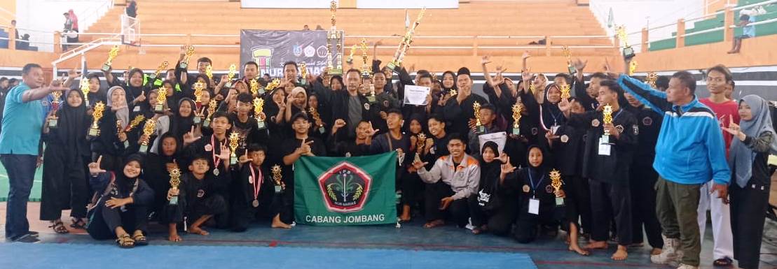 photo bersama: Ketua Dewan Pendekar Nur Harias Kabupaten Jombang, Imam Suhardi, (berdiri/ditengah bendera) usai menutup kejuara foro bersama dengan para pendekar yang meraih piala. di GOR Merdeka, Rabu (28/12/2022). 