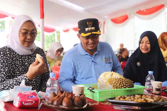 Tampak Sadarestuwati (kiri) mencicipi buah durian produk bumi Wonosalam bersama Pj Bupati Jombang didampingi istri, di lokasi kontes acara lapangan Desa Wonsalam, Minggu (9/2/2025)
