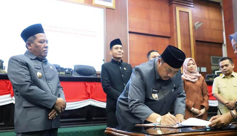 Bupati Jombang Abah Warsubi disaksikan Wakil Bupati, Ketua DPRD dan Wakil Ketua DPRD Kabupaten Jombang menandatangani berita acara disahkannya Raperda Perlindungan Perempuan dan Anak Korban Kekerasan di ruang para paripurna, DPRD setemat, Kamis (17/4/2025) 