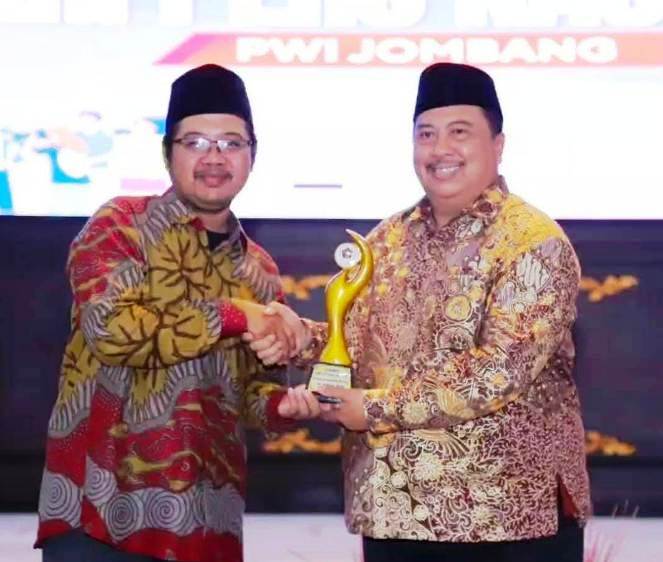 Dalam rangkaian acara Puncak HPN  (Hari Pers Nasional) dan PWI (Persatuan Wartawan Indonesia) Jombang Award 2025, Muhammad Mufid (kiri) menyerahkan penghargai kepada  
Bupati Jombang Warsubi, S.H., M.SI., Selasa (27/5/2025) di Pendopo Kabupaten Jombang.
