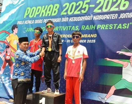 Kepala Sekolah salah satu SMPN di Kabupaten Jombang sedang menyerahkan medali Juara Atletik pada PORKAB Piala Kepala Dinas Pendidikan dan Kebudayaan Kabupaten Jombang Tahun 2025-2026, Rabu (01/10/2025) di Stadion Merdeka Jombang. 