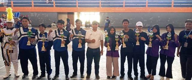 Kadisporapar Kabupaten Jombang, Drs Bambang Nuwijanto, M.Si (tengah/putih) photo bersama para juara kelompok SMA, usai melakukan penyerahan trophy juara “Jombang Cultural Merching Competition (JCMC) 2025” di GOR Merdeka, Sabtu (19/10/2025) sore. 