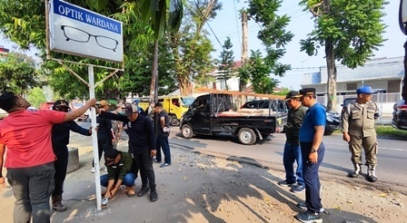 Sekdakab Jombang Agus Purnomo (biru/kedua dari kanan/berdiri) menyaksikan pemotongan papan reklame yg tidak sesuai aturan, Jum'at (23/6/2023). 