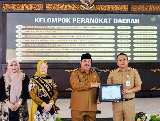 Didampingi Istri (kedua dari kiri), Bupati Jombang H Warsubi menyerahkan piagam kepada Roni, Plt Camat Mojowarno. Hadir pada acara tersebut Wakil Bupati Jombang Salmanudin Yazid, Asisten, Staf Ahli, segenap Kepala OPD, Camat se Kabupaten Jombang, serta siswa-siswi lingkungan Pendopo Kabupaten Jombang, Senin (25/8/2025). 