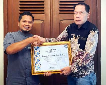 Direktur Perumda Aneka Usaha Seger, Mohammad Nasir (kanan), menerima penghargaan dari Direktur Memorandum, Yoyok Khayatullah dalam seremoni resmi yang juga dihadiri para tamu undangan lembaga, instansi, pelaku usaha, Rabu (12/11/2025).