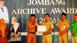Bupati Jombang yang diwakili oleh Sekretaris Daerah Kabupaten Jombang Agus Purnomo S.H., M.Si menyerahkan penghargaan kepada Thonsom Pranggono A.P., M.E., Kepala Dinas Perpustakaan dan Kearsipan (Disperpusip) sukses menempati urutan pertama dengan raihan nilai tertinggi sebesar 98,10 (meningkat dari 89,65 di tahun 2025). 