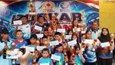 Ketua Cabor Akuatik Indonesia Kabupaten Jombang Drs Anang Masruchin, M.Si (kanan) didampingi Pengurus IA Jombang photo bersama atlet peraih medali terbaik pada kelompok usia sembari menunjukkan hadiah uang pembinaan.