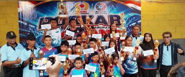 Ketua Cabor Akuatik Indonesia Kabupaten Jombang Drs Anang Masruchin, M.Si (kanan) didampingi Pengurus IA Jombang photo bersama atlet peraih medali terbaik pada kelompok usia sembari menunjukkan hadiah uang pembinaan. 